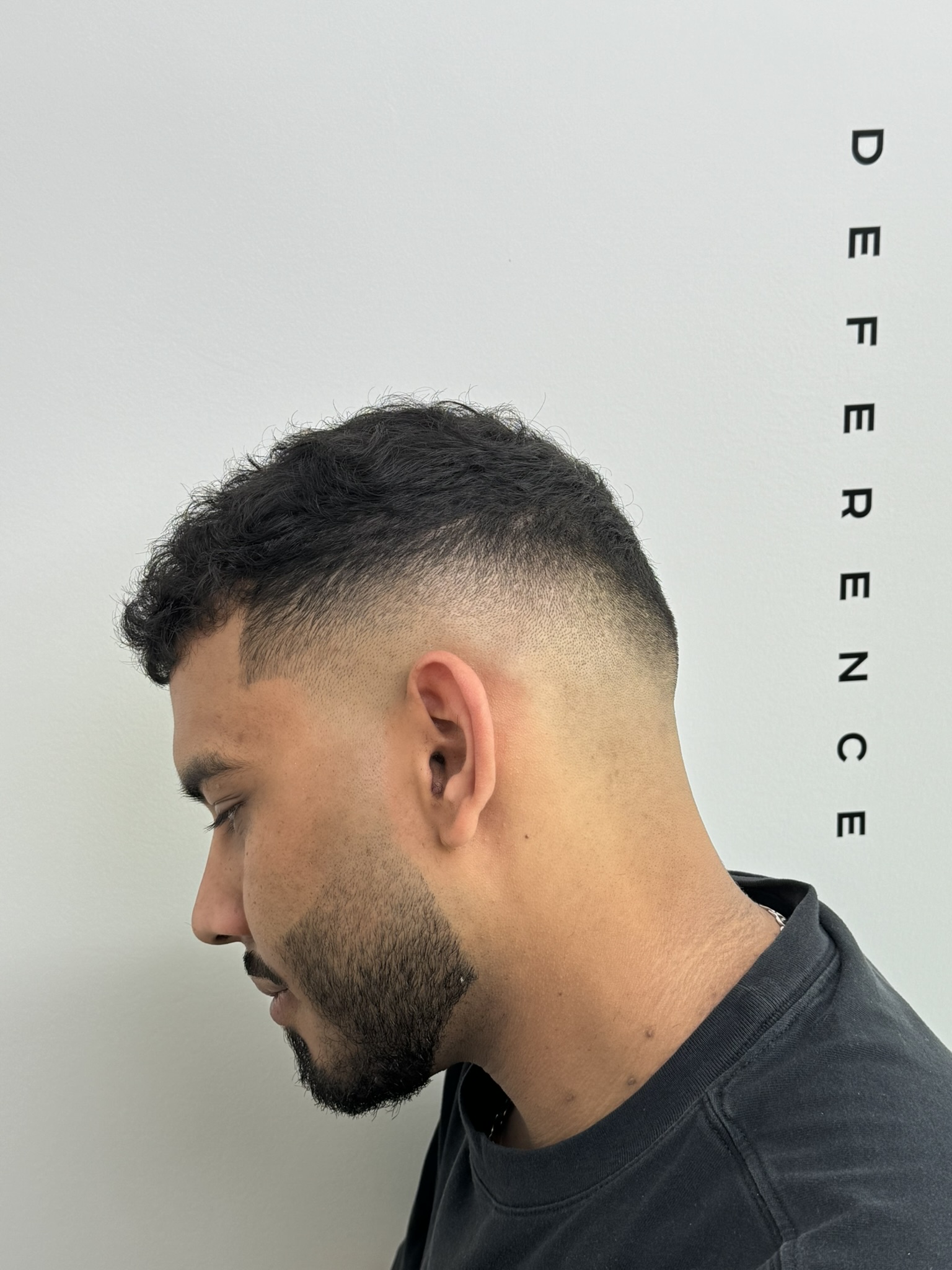 Magas skin fade férfi hajvágás szakállal a Deference Barbershopban